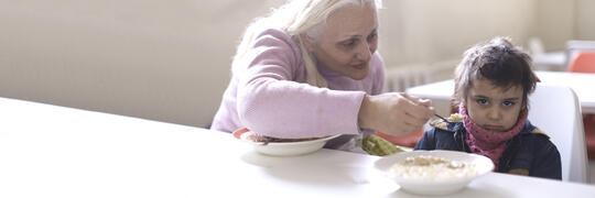 grandmother feeding her grandchild in the AGBU Soup Kitchen